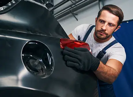 Picasso Dent Repair technician working a dent out of a vehicle panel in the Spokane Valley shop